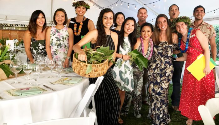 A group of people smiling and posing together at a wedding during the Green Gala celebration.