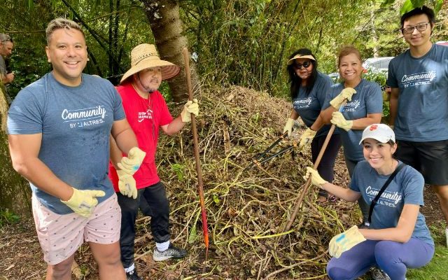 A group of Altres team members smiling for a photo as they participate in an outdoor Day of Service.