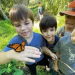 A student holding a butterfly.