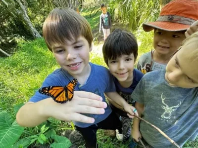 A student holding a butterfly.