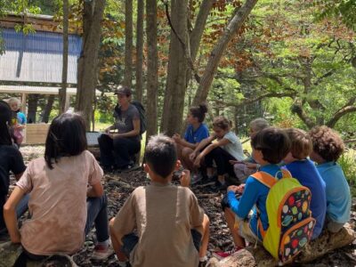 Students gather around to listen to environmental educator