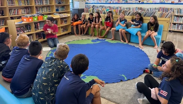 Children gather around an educator indoors